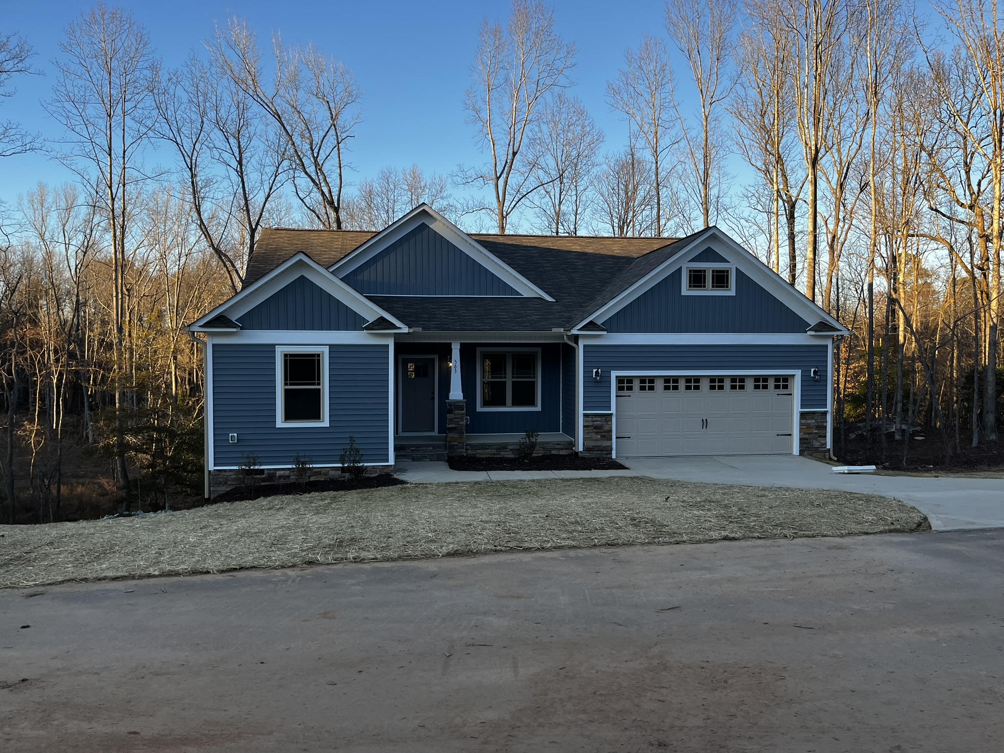 Finished blue craftsman-style ranch home with stone accents, front elevation