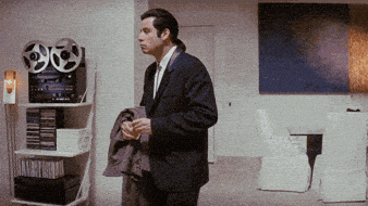 John Travolta confused in Pulp Fiction — representing a superintendent trying to do every trade's job alone