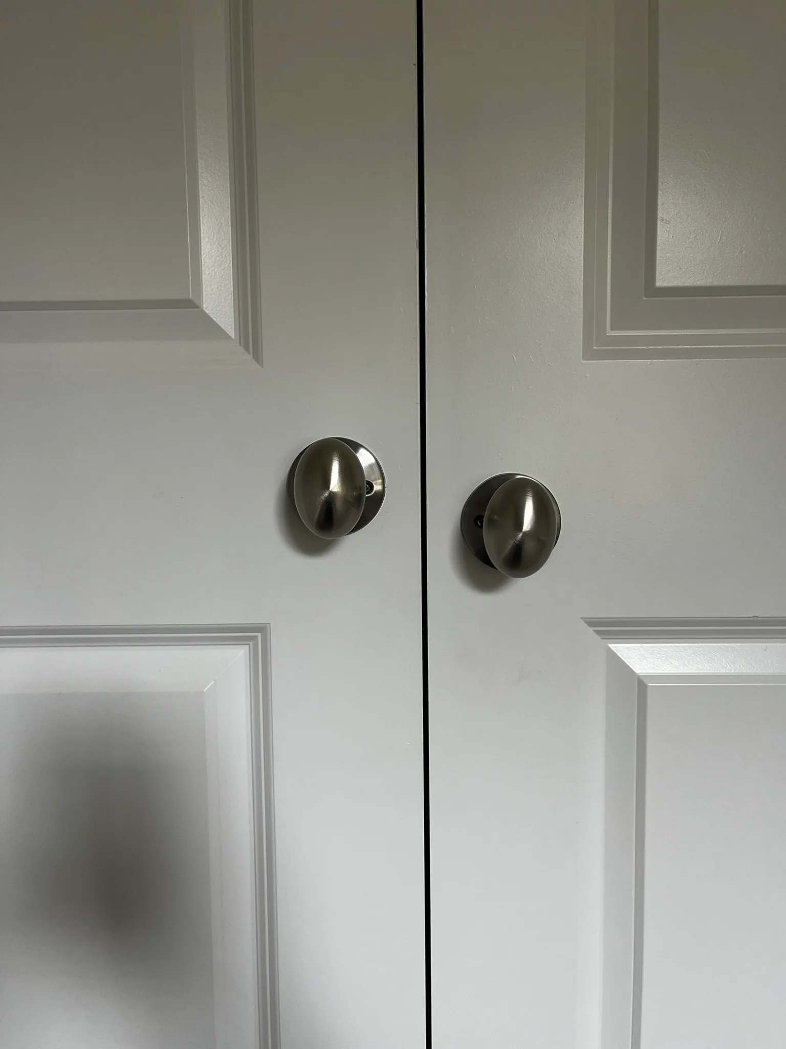 Two door knobs installed at noticeably different heights on adjacent doors