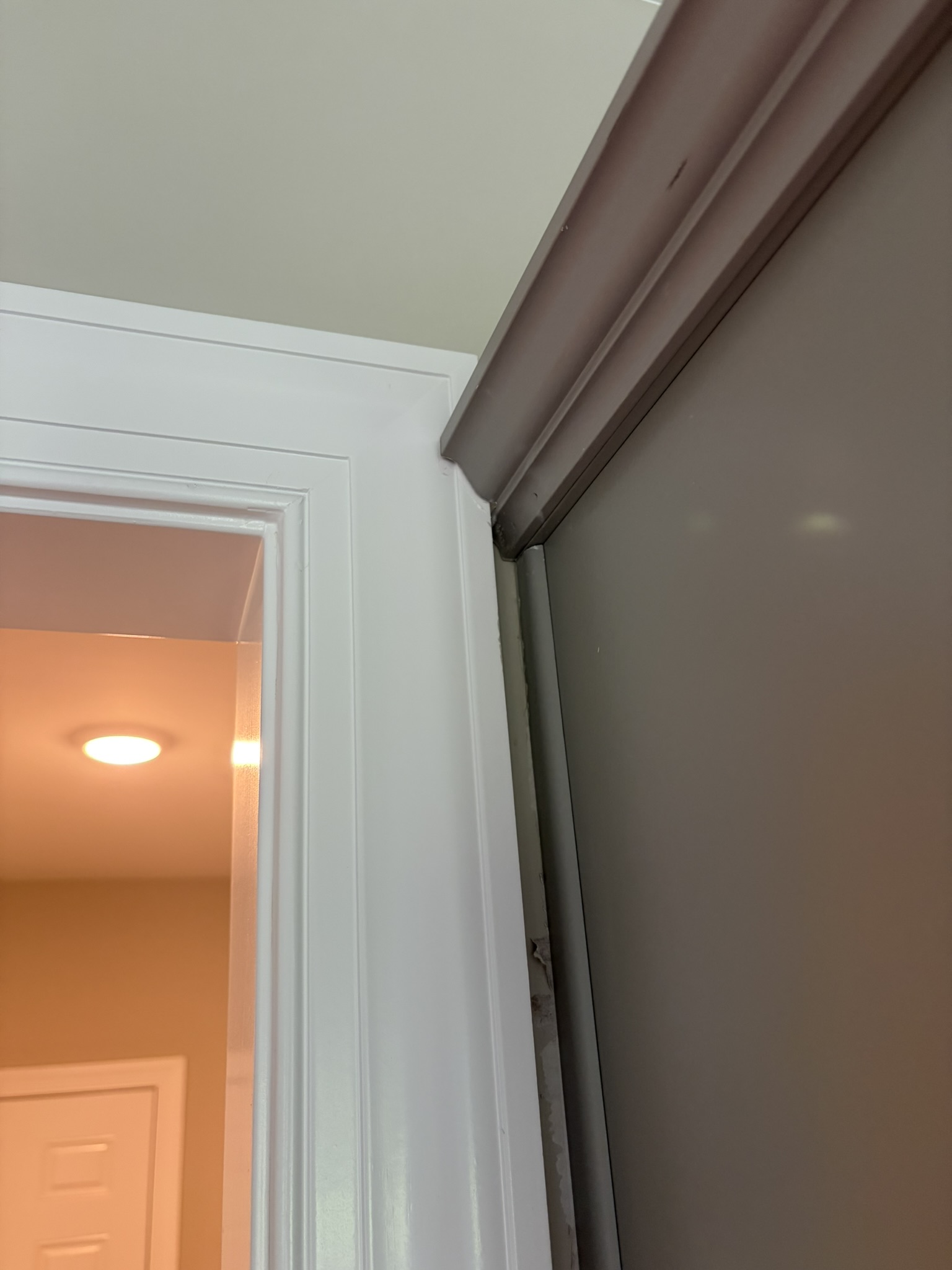 Cabinet crown molding running into door casing at a cased opening between kitchen and living room